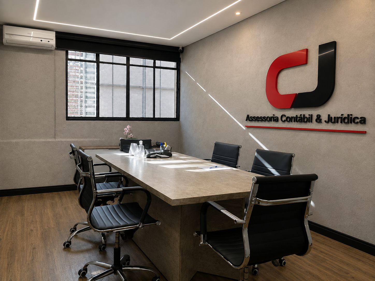 Sala de reunião do escritório da CJ Assessoria Contábil e Jurídica, com a logo CJ na parede